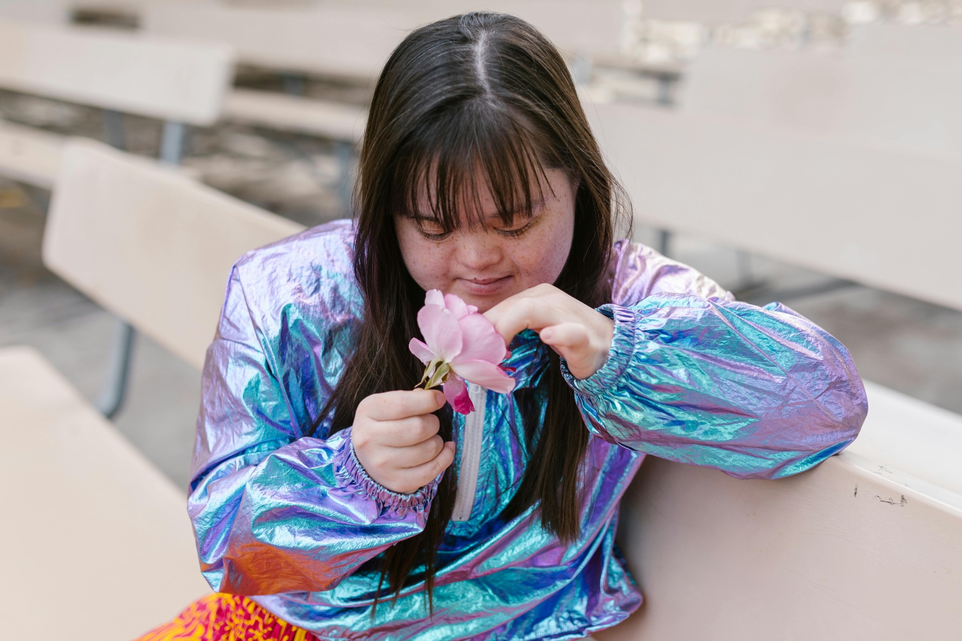 Young woman with disability enjoying a flower outdoors
